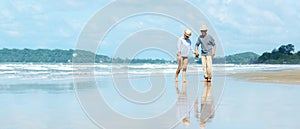 Asian Lifestyle senior couple walking chill on the beach happy in love romantic and relax time after retirement.Â 